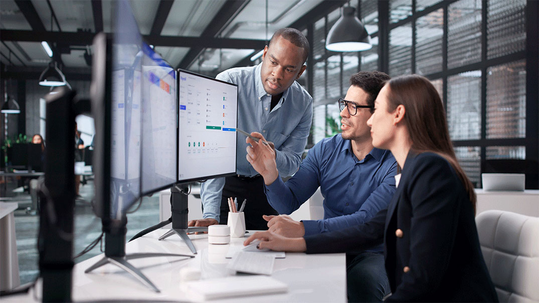 a group of people working looking at the same computer screen