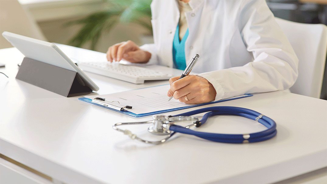 a doctor writing on a clipboard