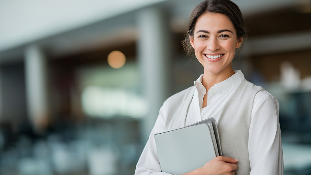 Administrative professional holding a laptop.