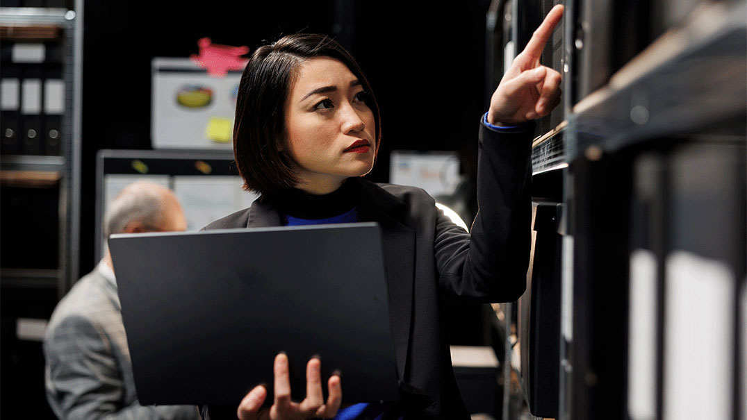 a woman holding a computer and pointing at a files