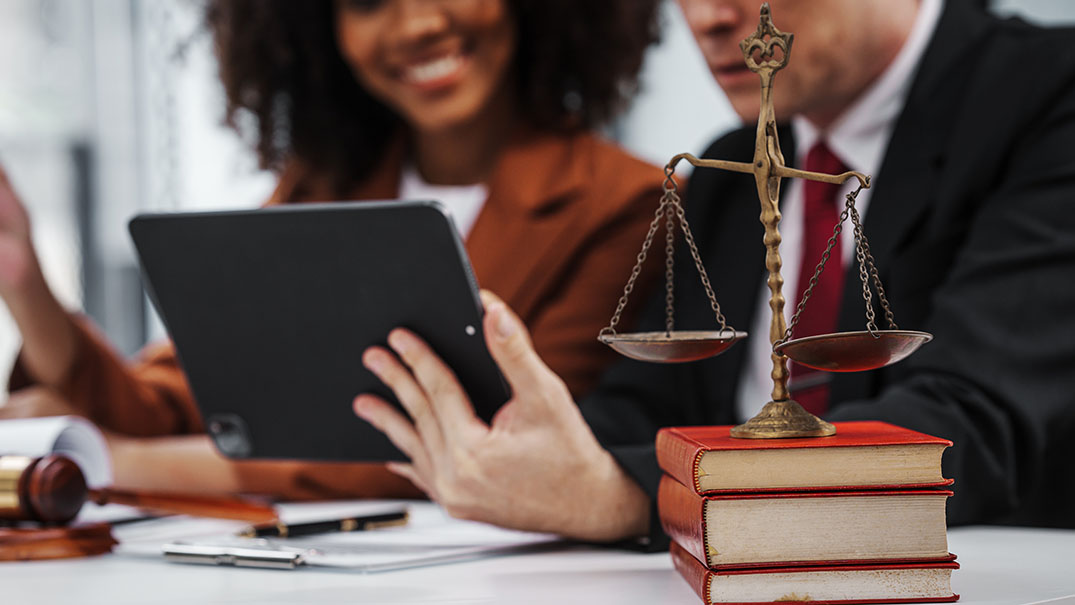 Legal professionals reviewing information with a digital device.