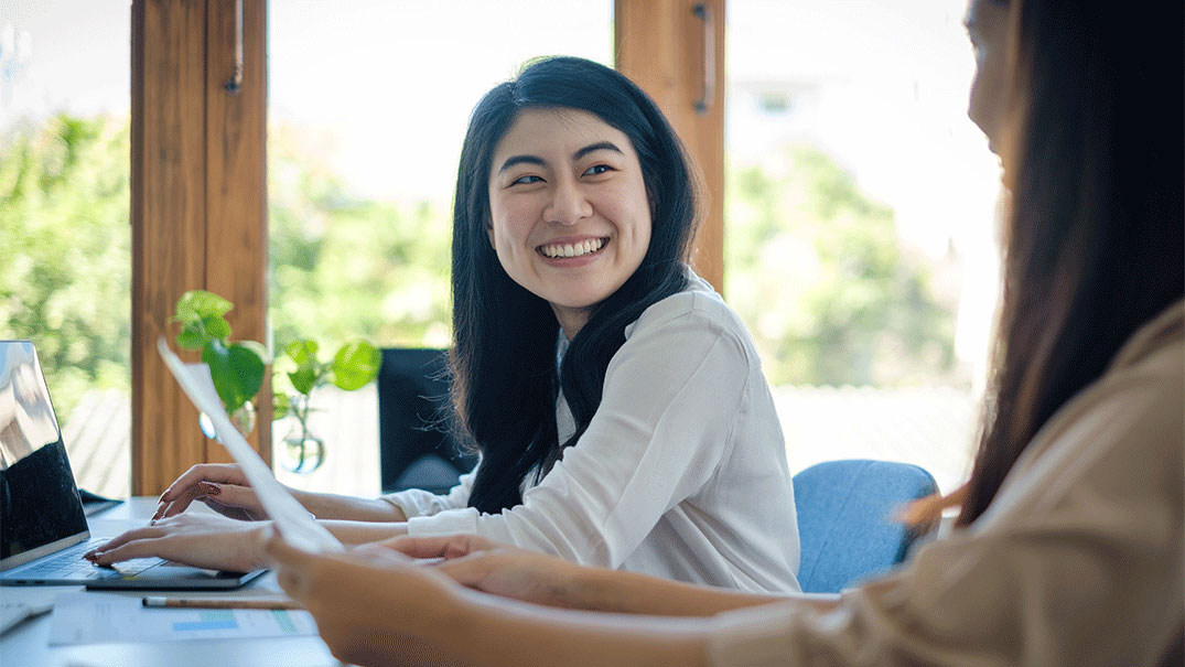 a woman smiling at another woman