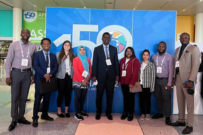 Dr. Jeff Inungu stands with eight CMU students at the American Public Health Conference