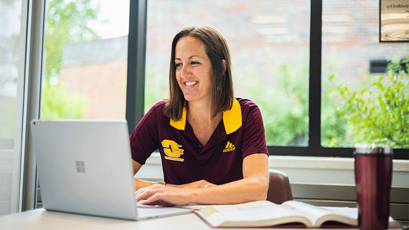 a woman sitting at a desk with a laptop