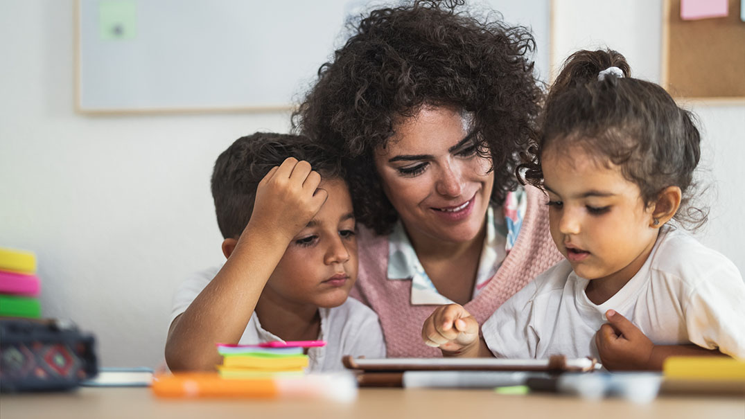 Teacher helping children learn to read